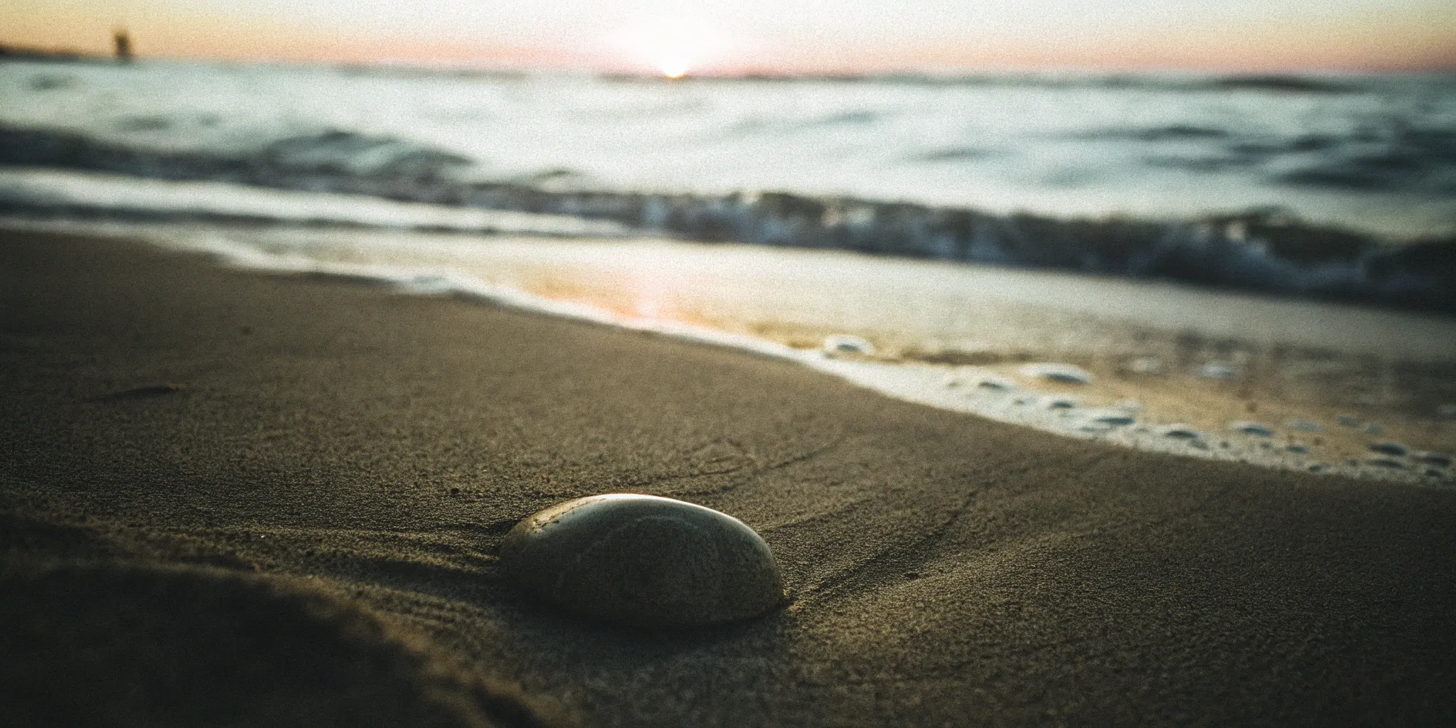 A smooth stone on a beach representing the vitality and recovery benefits of exosome infusion.