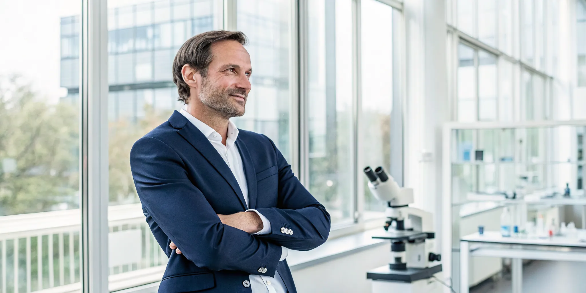 Man in a modern lab with a microscope for stem cell hair regrowth for men.